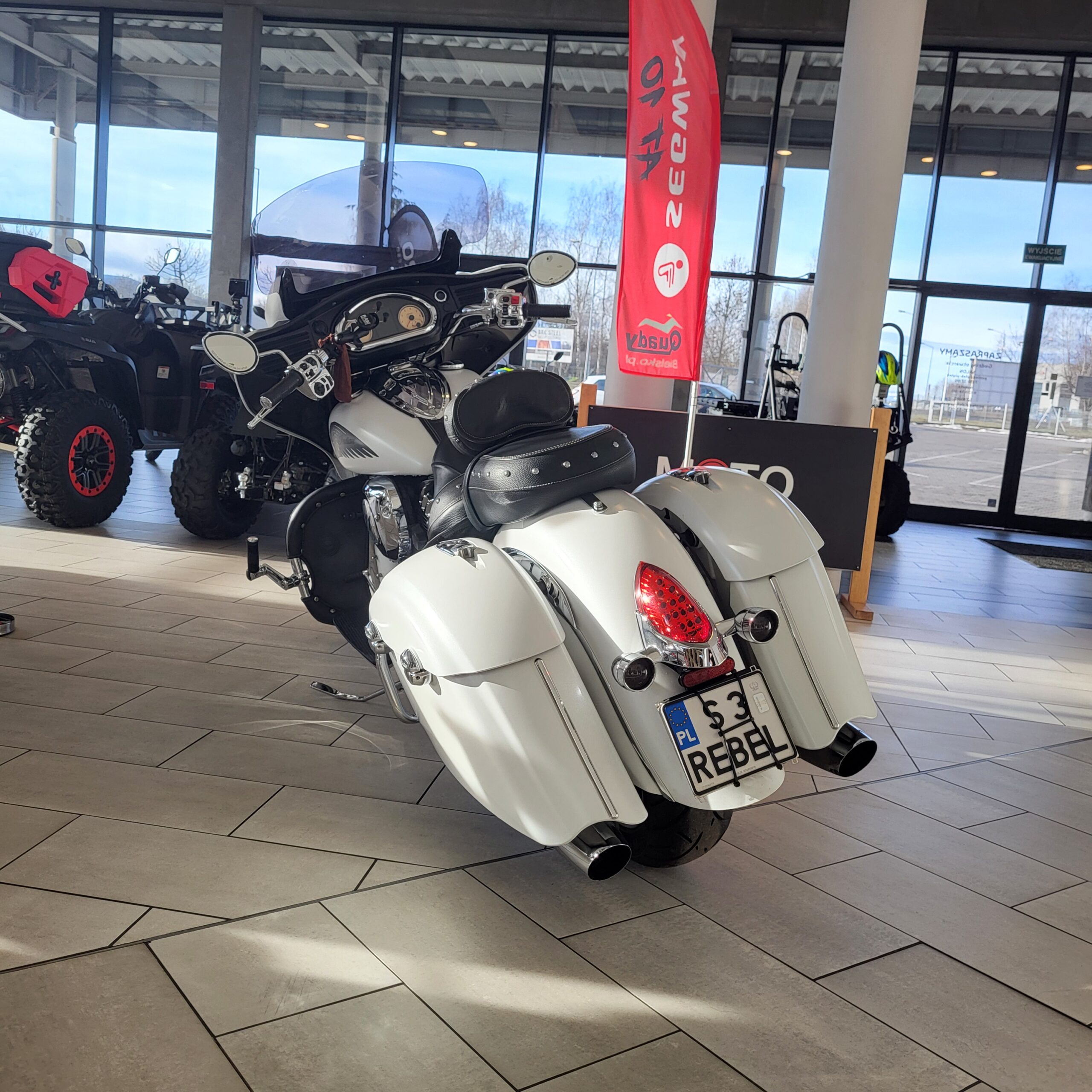 Biały motocykl Indian Chieftain 2016 z kuframi i szybą przednią.