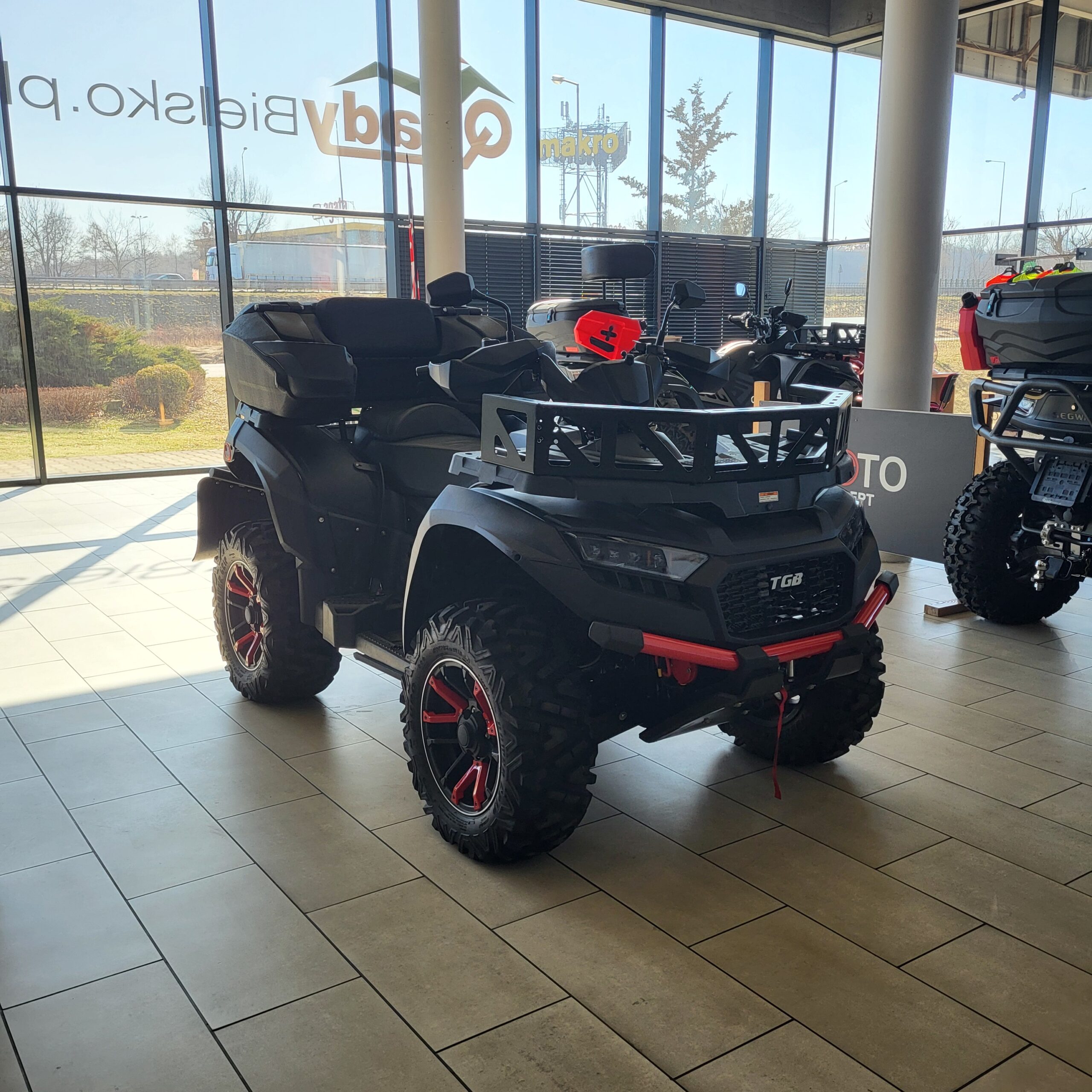 ATV TGB Blade 1000 LTX MAX: Czarny quad z czerwonymi akcentami w salonie.