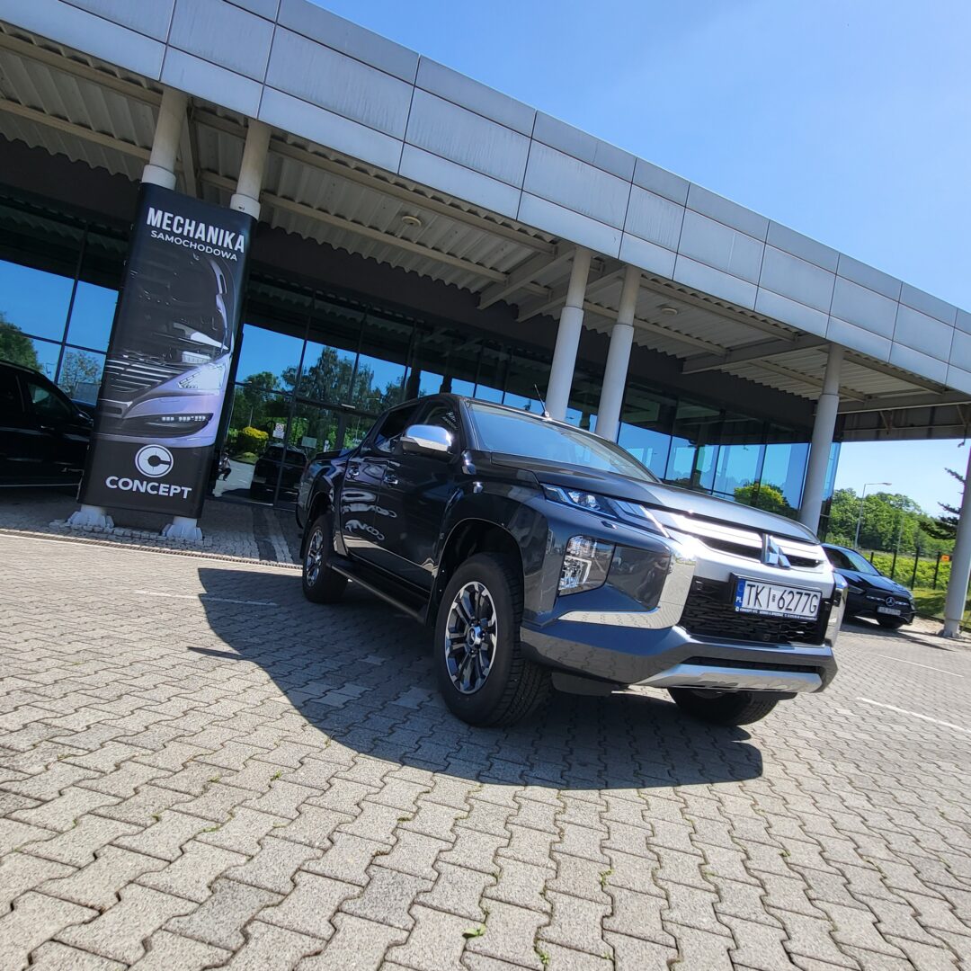 Ciemnoszary Mitsubishi L200 2.2DiD InStyle 2019 na parkingu przed salonem.