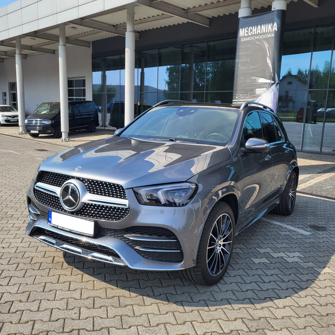 Nowy SUV Mercedes-Benz GLE580 4Matic 2022 w kolorze szarym parkowany przed salonem samochodowym.