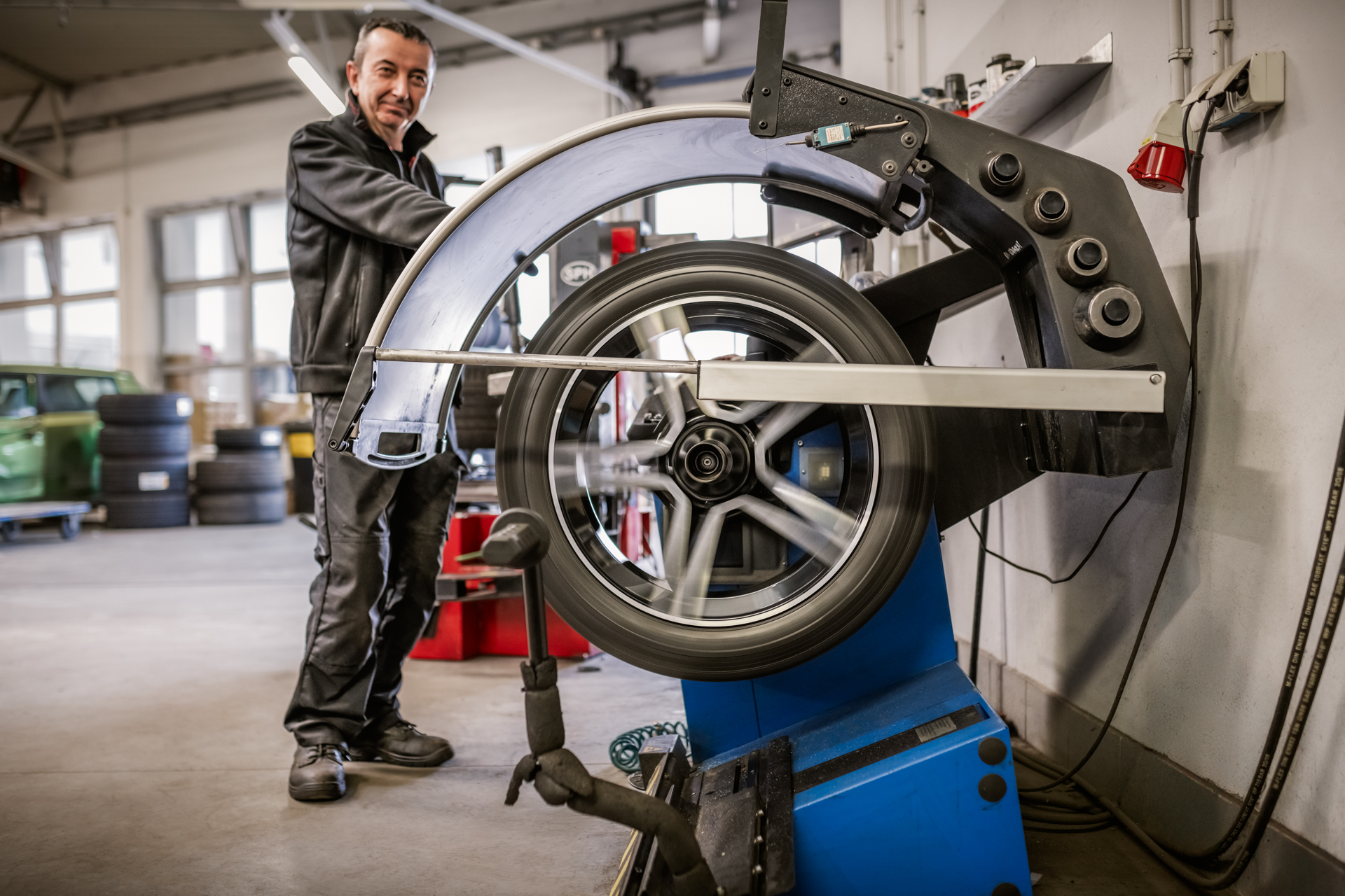 Mechanik używający maszyny do montażu opon w warsztacie samochodowym