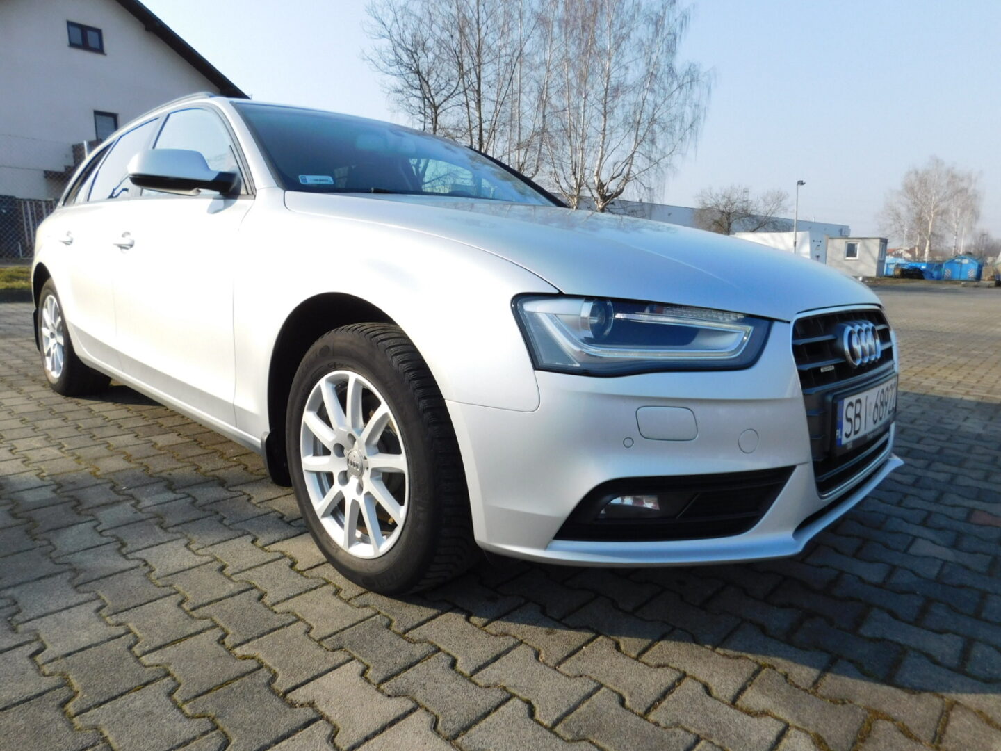 Srebrne Audi A4 Avant na parkingu, widok z przodu.