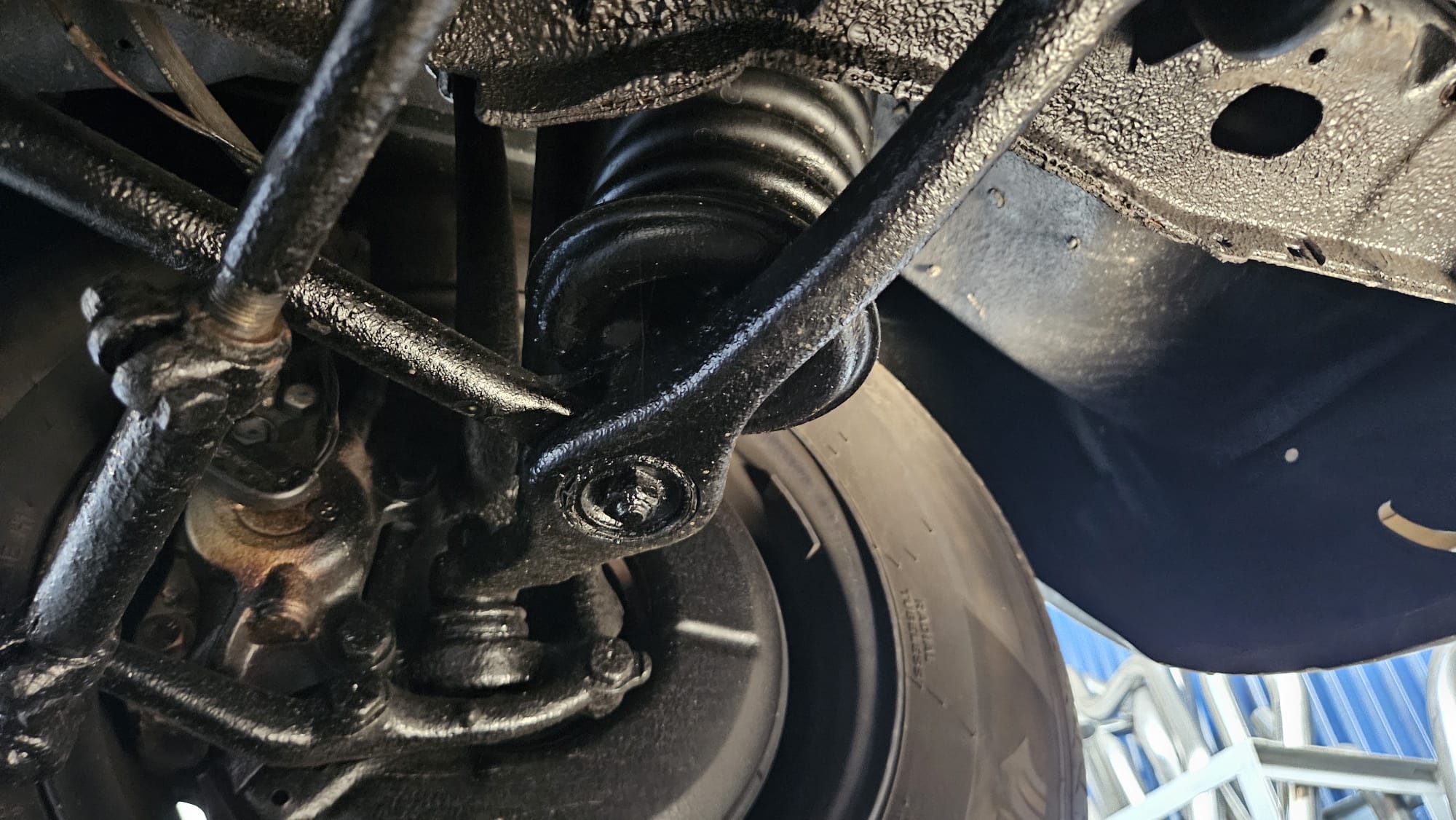 Zawieszenie Mercedes-Benz W123: widok od dołu na sprężynę i element zawieszenia.