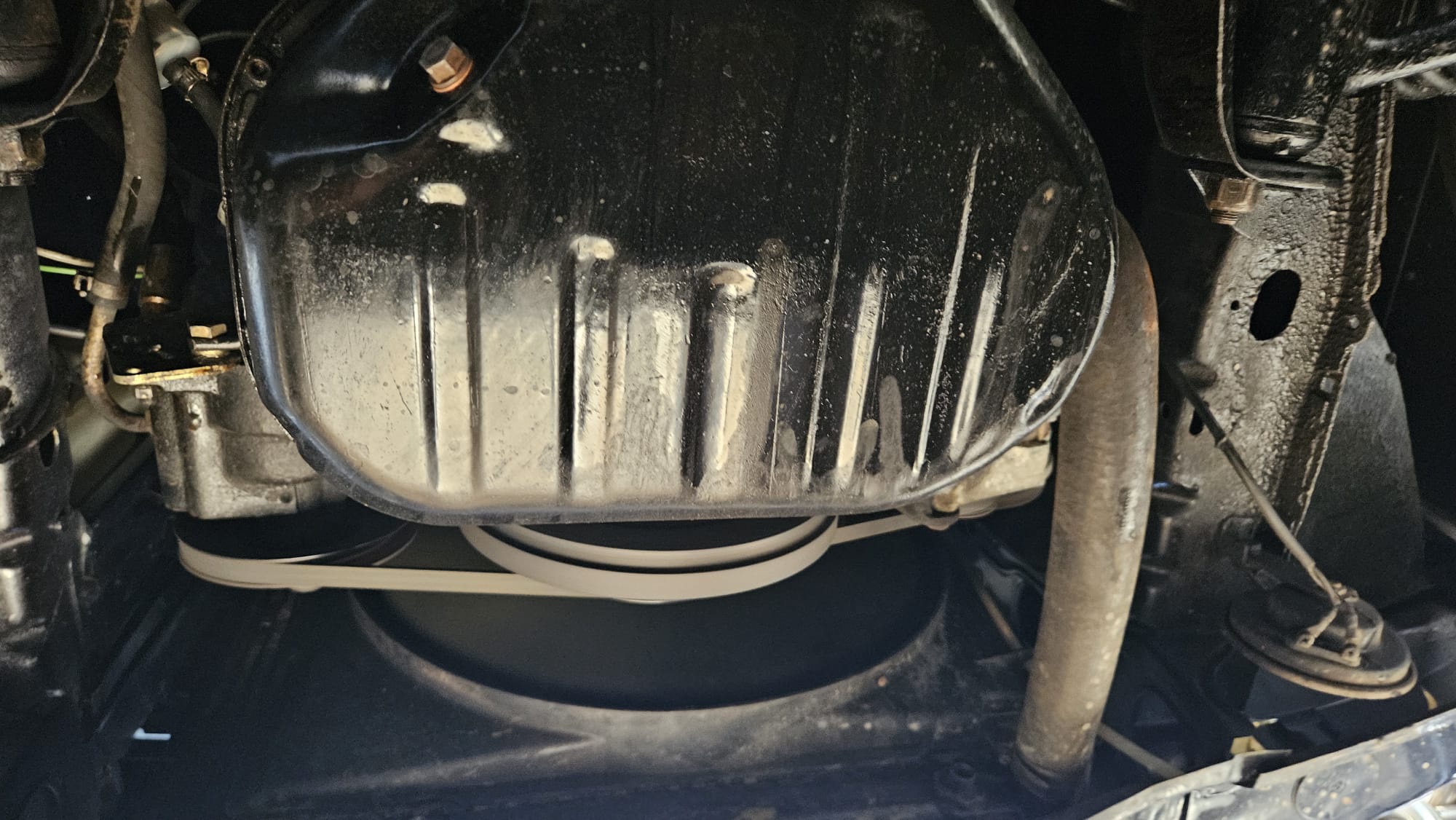 Miska olejowa i pasek napędowy Mercedesa W123 pod maską samochodu.